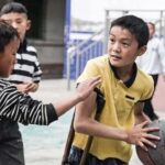 One-legged China teen boy dreams of basketball glory, practising with a crutch made by dad
